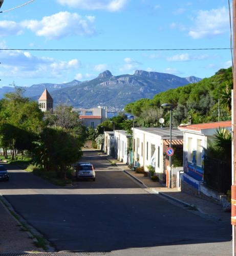a street in a town with mountains in the background at Borgo Marinaro La Medusa Arbatax - camera matrimoniale con bagno privato- in Àrbatax