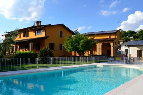 a large swimming pool in front of a house at Agriturismo Bortolino in Volta Mantovana