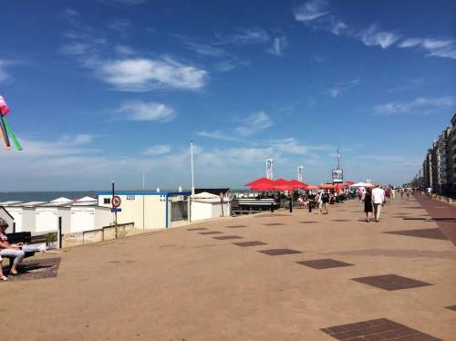 a group of people walking on a boardwalk at Apartment with a view and parking in Knokke-Heist