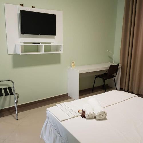 a bedroom with a bed with a tv on the wall at Paracambi Top Hotel in Paracambi