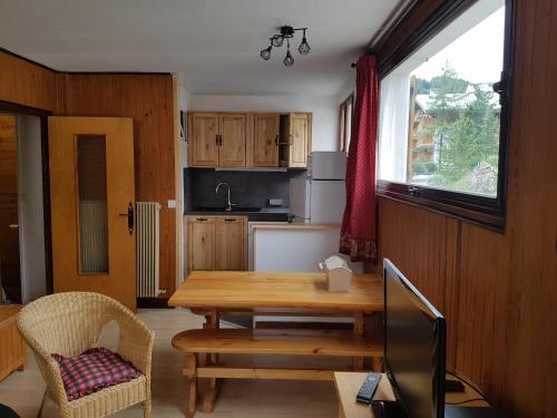 Una cocina con una mesa de madera y un comedor. en Le Petit Chalet, en Auron