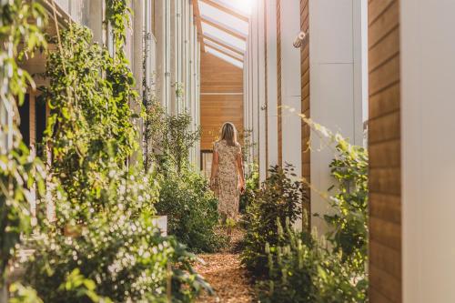 a woman walking down a hallway with plants at Eklo Bordeaux Centre Bastide in Bordeaux