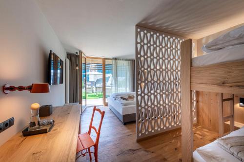 a room with two bunk beds and a desk and a bedroom at Hotel Platz in Ortisei