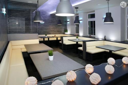 a restaurant with tables and chairs and potted plants at Národní dům Podbořany in Podbořany
