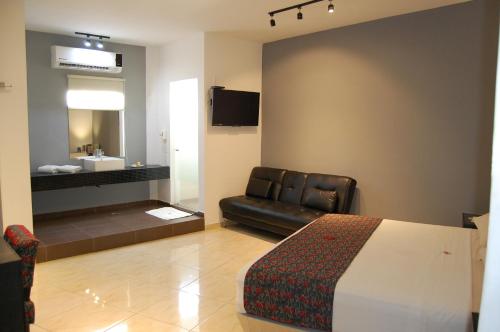 Habitación de hotel con cama, sofá y lavamanos en Hotel Dulce Boca en Veracruz