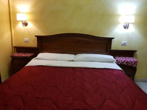 ローマにある3 Lati di Pitagora B&Bのベッド1台(赤毛布、枕2つ付)