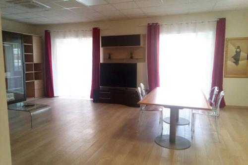 ローマにあるVetere 101 Apartmentのテーブルと椅子、テレビが備わる客室です。