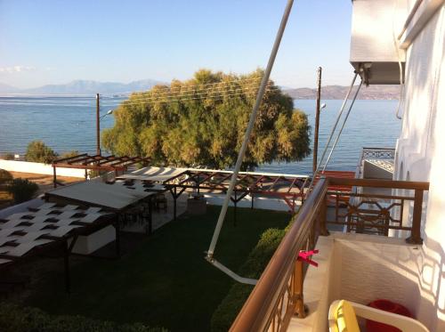 a balcony with tables and a view of the water at Chris Studios & Apartments in Lechaio