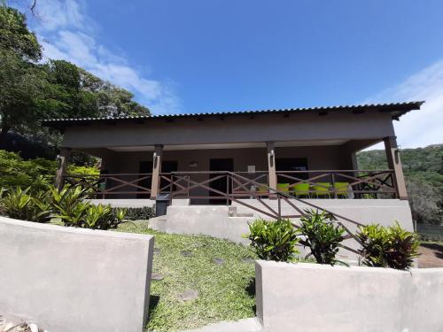 a house in the middle of a field at WHITE SHARK RESORT in Ponta do Ouro