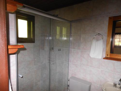 a bathroom with a shower with a toilet and a sink at Grunwald Chales in Monte Verde