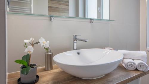 La salle de bains est pourvue d'un lavabo blanc sur un comptoir en bois. dans l'établissement Dolac Design Apartment 8, à Zagreb