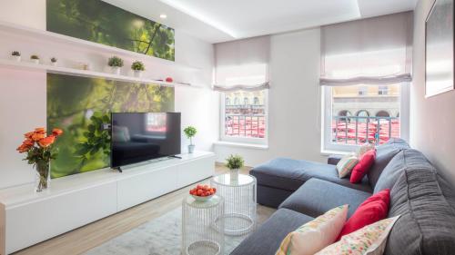 un salon avec un canapé bleu et une télévision dans l'établissement Dolac Design Apartment 8, à Zagreb