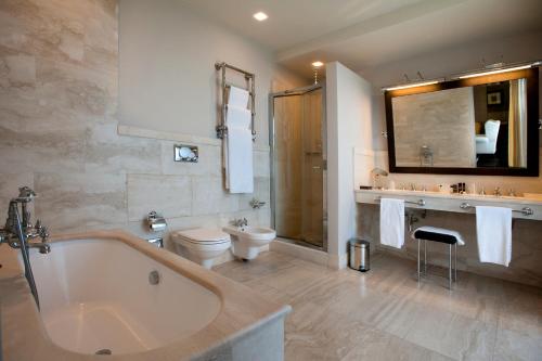 a bathroom with a tub and a toilet and a sink at Relais Villa D'Amelia in Benevello
