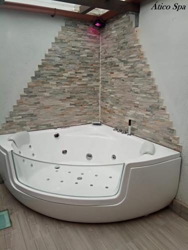a white bath tub sitting in front of a brick wall at Casas Toya Jacuzzi in Uceda