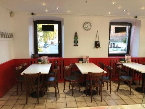 a restaurant with tables and chairs and a clock on the wall at Hotel Einstein in Bad Krozingen