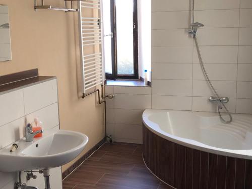 a bathroom with a bath tub and a sink at Hotel Einstein in Bad Krozingen