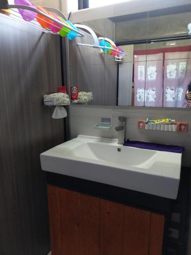 y baño con lavabo blanco y espejo. en 蘭嶼老鍋蓋民宿 en Lanyu