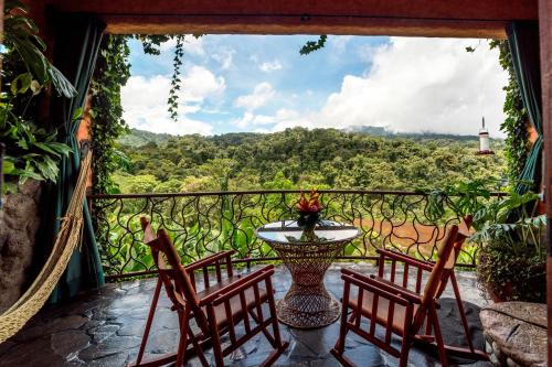 a balcony with two chairs and a table with a view at Peace Lodge in Vara Blanca