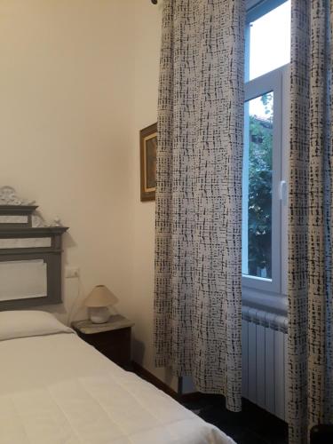 a bedroom with a bed and a window with curtains at Villa Sapi in Arcisate