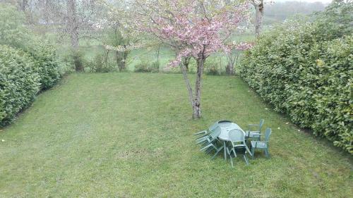 a table and chairs in a yard with a tree at Gite 3étoiles Coconning dans une grange cantalienne - Cantal Emotions Valette Auvergne in Valette