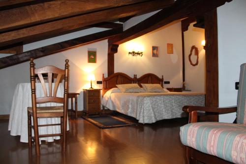 un dormitorio con una cama y una silla en La Posada de Viñón - Casa Reda, en Viñón
