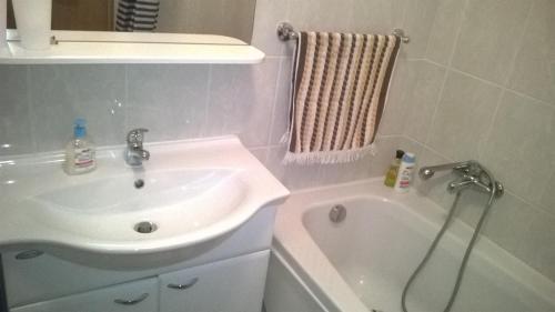 ein Badezimmer mit einem Waschbecken und einer Badewanne in der Unterkunft Apartman Mario in Osijek