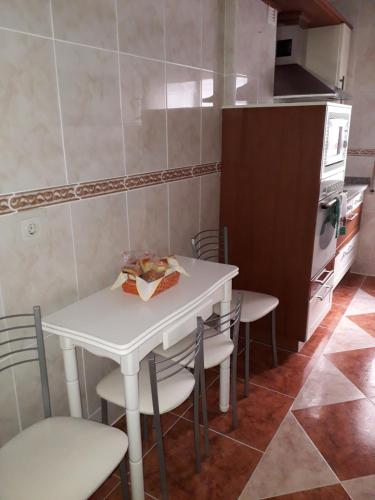 a small kitchen with a white table and chairs at Piso María in Arévalo