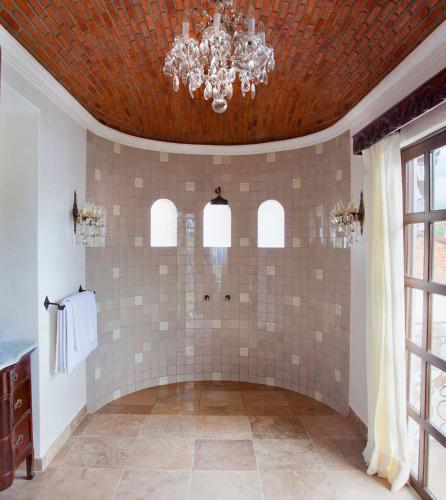 a bathroom with a chandelier and a tiled wall at Casa Kimberly Boutique Hotel in Puerto Vallarta