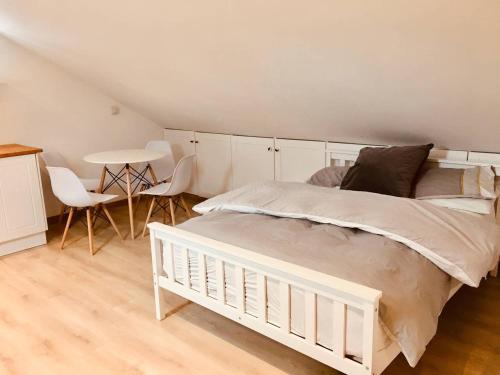 een slaapkamer met een wit bed en een tafel en stoelen bij Oak Tree Studio in Marlow