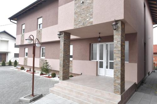 um edifício cor-de-rosa com uma porta branca e escadas em Olimp em Kraljevo