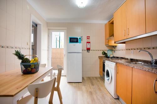 a kitchen with a white refrigerator and a dishwasher at Casa Bom Dia 27 in Sintra