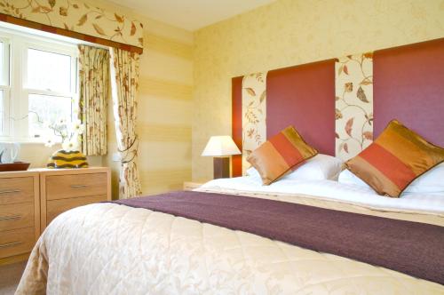 Un dormitorio con una cama grande y una ventana en The Tomich Hotel en Tomich