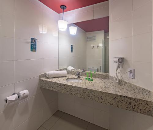 ein Bad mit einem Waschbecken und einem Spiegel in der Unterkunft ibis Styles Franca in Franca