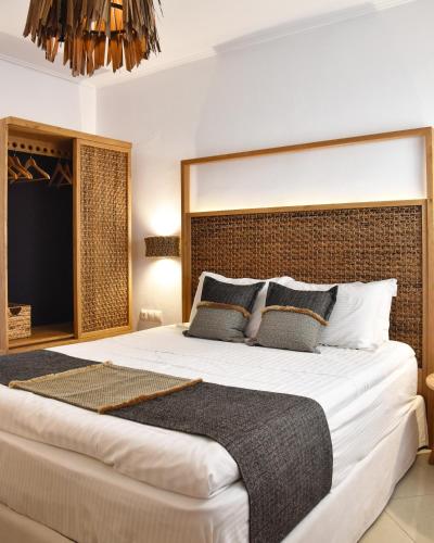 a bedroom with a large bed with a large headboard at Angelos Design Suites in Patitiri