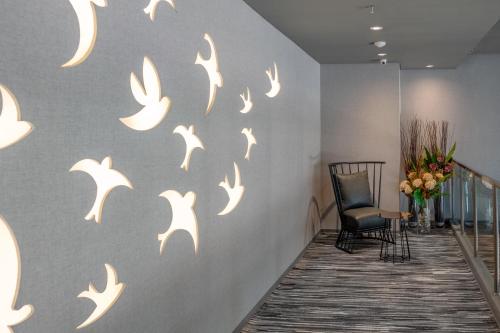a hallway with white birds stenciled on a wall at Stanley Wahid Hasyim Jakarta in Jakarta