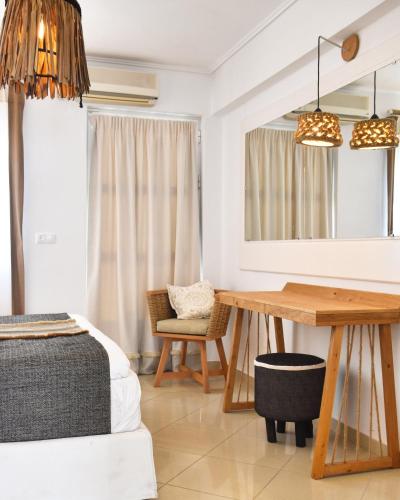 a room with a table and a chair and a mirror at Angelos Design Suites in Patitiri