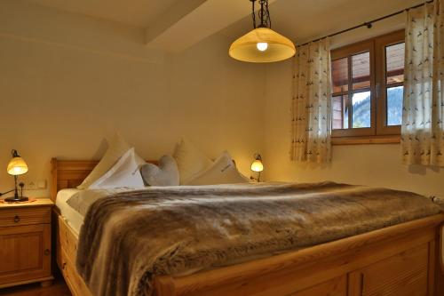 a bedroom with a large bed and a window at Bauernhof Waldesruh in Tannheim
