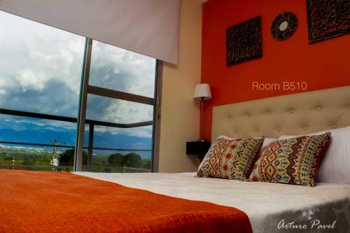 a bedroom with a bed with a large window at Apartamento cerca al Parque del Café, Eje Cafetero in Montenegro