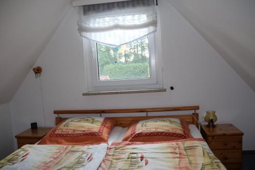 - une chambre avec un lit et une fenêtre dans l'établissement Ferienwohnung Wiesenblick, à Prerow