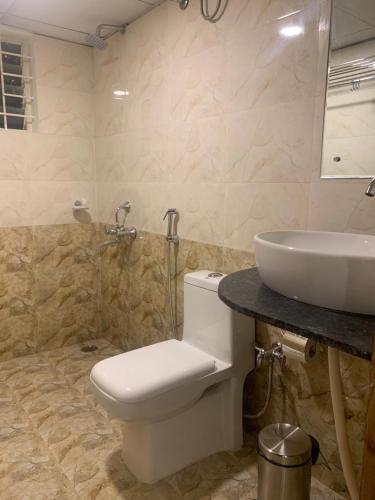 a bathroom with a toilet and a sink at Hotel Airport City in Bangalore