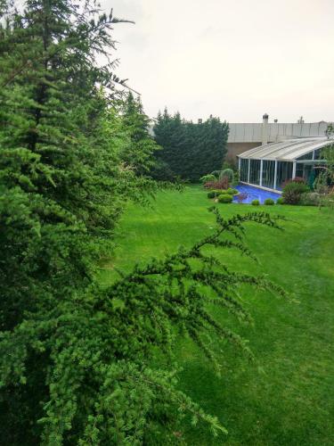 a green yard with a building and a tree at Baia Bursa Hotel in Bursa