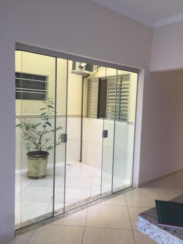 an empty room with glass doors and a potted plant at Suites Clima da Serra in Cunha