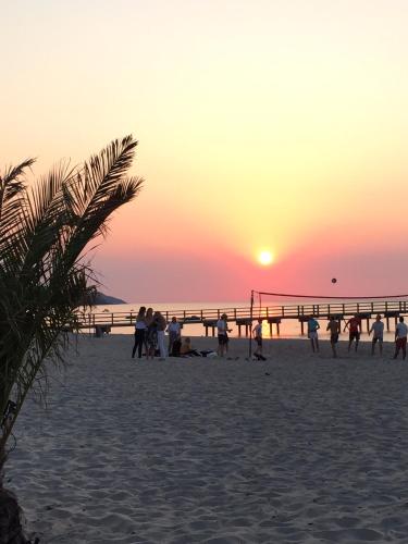 a group of people on the beach at sunset at Tree Top Hill - The Old Station House - Båstad Holiday Apartments in Båstad