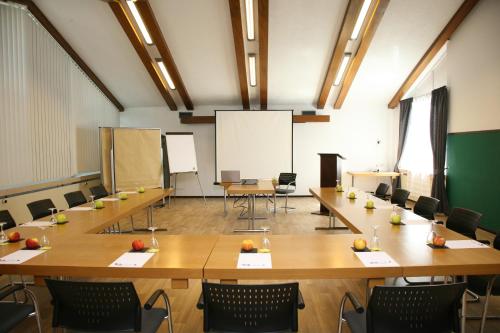 a large room with tables and chairs and a whiteboard at Hotel Pflug in Ottenhöfen