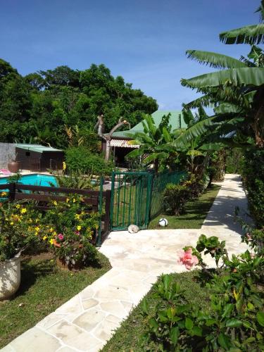 a garden with a fence and a pool at Gite bagatelle classé 2 étoiles in Sainte-Rose