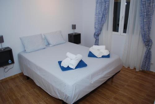 1 dormitorio con 1 cama con toallas en Villa Bello Horizonte, en Pedreguer
