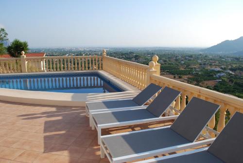 a deck with lounge chairs and a swimming pool at Villa Bello Horizonte regio Denia - Javea in Pedreguer