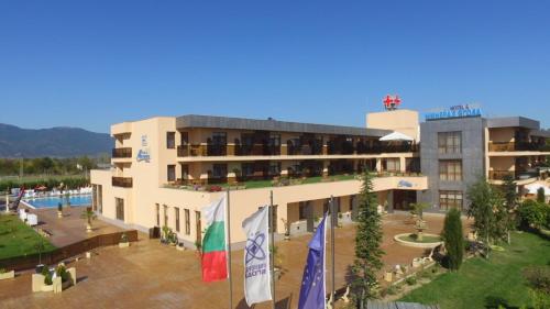 a hotel with flags in front of a building at Balneo and SPA Complex MINERAL YAGODA in Yagoda