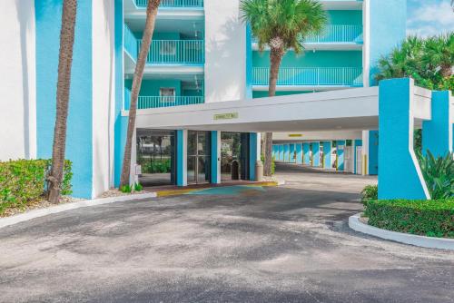 a building with palm trees in front of it at GetAways at Turtle Reef Club in Jensen Beach