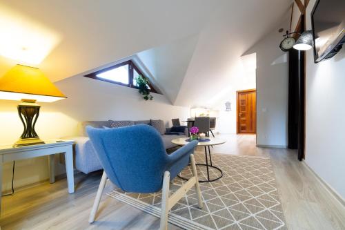 a living room with a blue chair and a table at Rasos Vila in Palanga